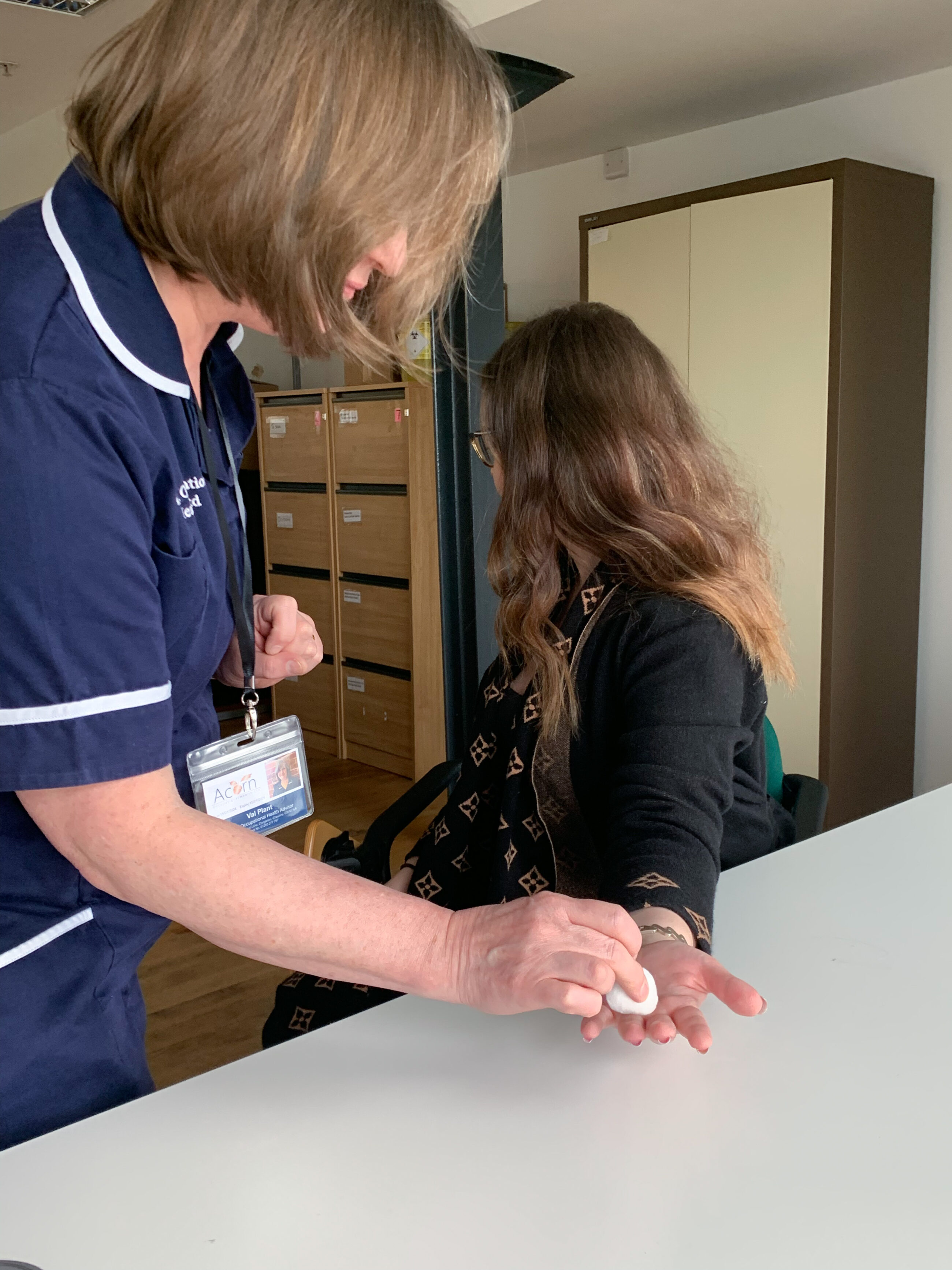 A nurse is touching cotton wool on someone's hand to test for HAVS